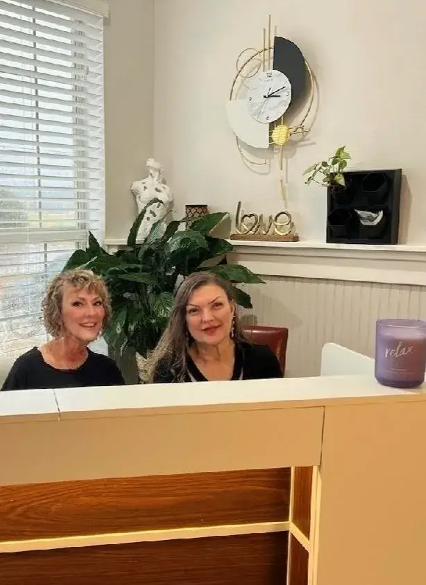 Sisters Marcie and Esther at the reception desk of Worth It Beauty and Wellness